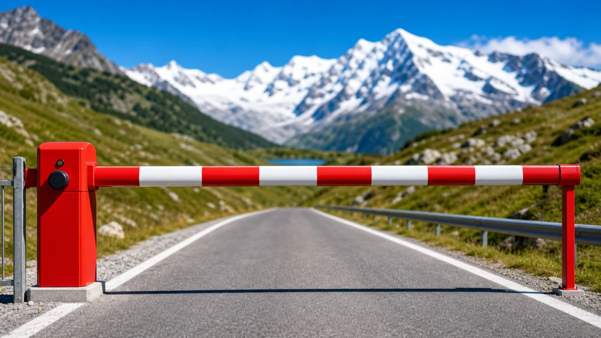 Symbolbild: rote und weisse Schranke auf einer alpinen Strasse
