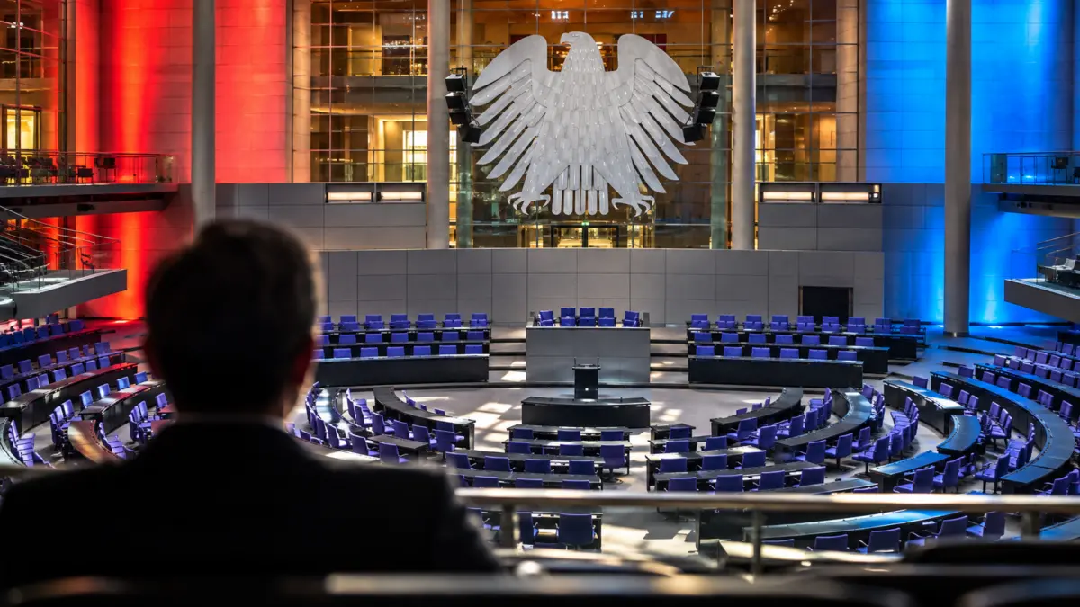 Blick in einen symbolisch dargestellten Bundestagssaal mit Bundesadler