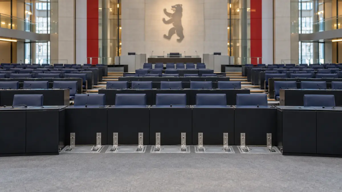 Leerer Berliner Plenarsaal mit entfernten Sitzen in der ersten Reihe