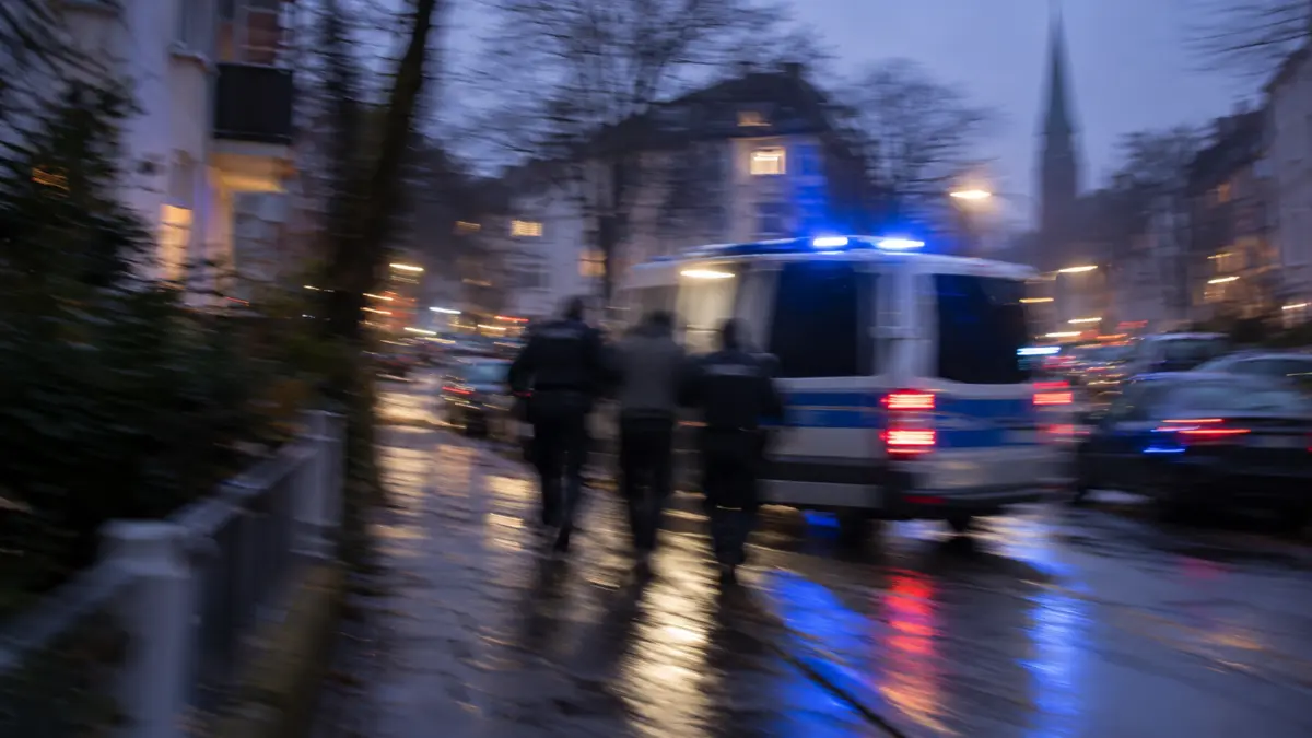 Stark verwischte, nicht erkennbare Silhouetten bei einer Festnahme neben einem Polizeiwagen